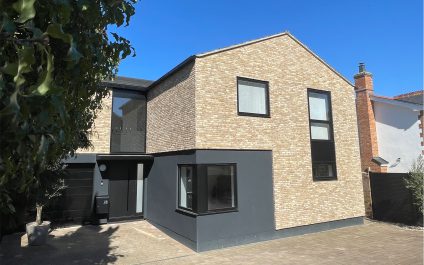 Fully refurbished modern house in Saffron Walden with yellow brick exterior, black render ground floor, and contemporary black-framed windows, located on West Road near a conservation area.