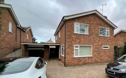 Front view of a house in Saffron Walden with a flat roof garage, featuring original facing red bricks near a conservation area.